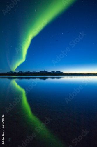 A curtain of Aurora Borealis or Northern Lights reflects in the quiet water of the Kelly River in the Noatak National Preserve, Alaska, USA.
