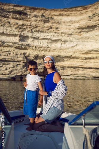 mother and son in a swimsuit sitting on the bow of speedboat in the summer on vacation © saulich84