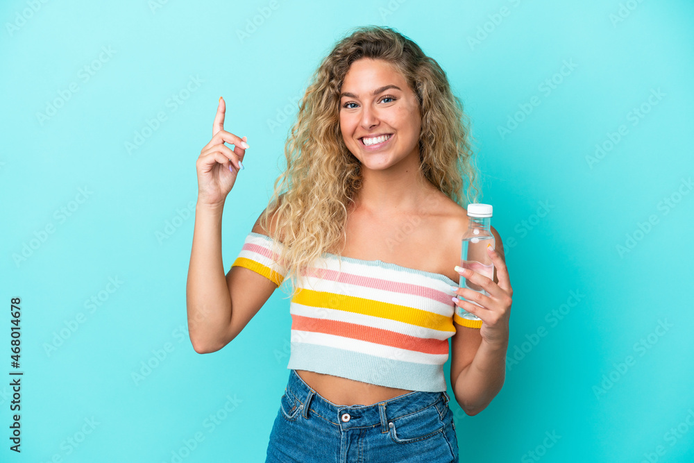 Young blonde woman with a bottle of water isolated on blue background pointing up a great idea Young blonde woman with a bottle of water isolated on blue background pointing up a great idea