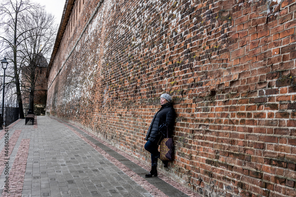 woman tourist gets acquainted with the sights of Nizhny Novgorod on an autumn cloudy day 