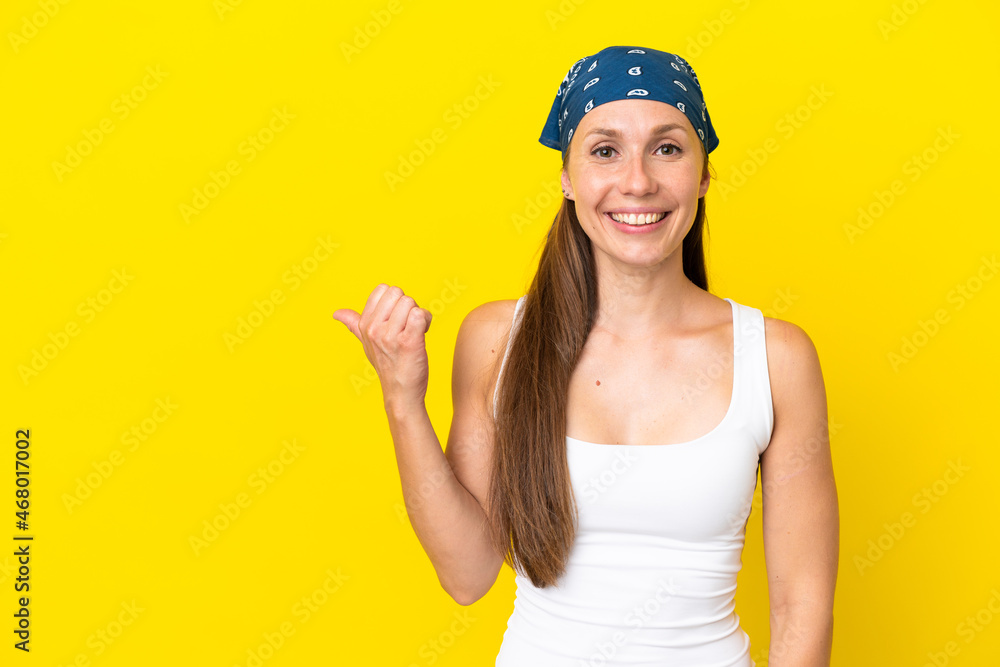 Young English woman isolated on yellow background pointing to the side to present a product Young English woman isolated on yellow background pointing to the side to present a product