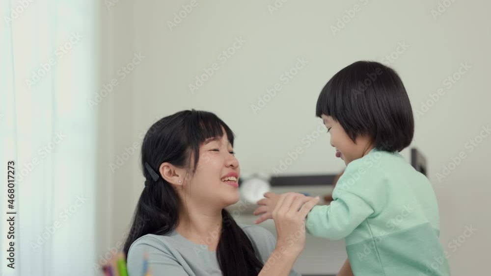Happy asian boy hugging his mother while painting crayon and colored pencil in living room at home. Mom teaching son how to painting with crayon having fun in the house. family love concept. Happy asian boy hugging his mother while painting crayon and colored pencil in living room at home. Mom teaching son how to painting with crayon having fun in the house. family love concept.