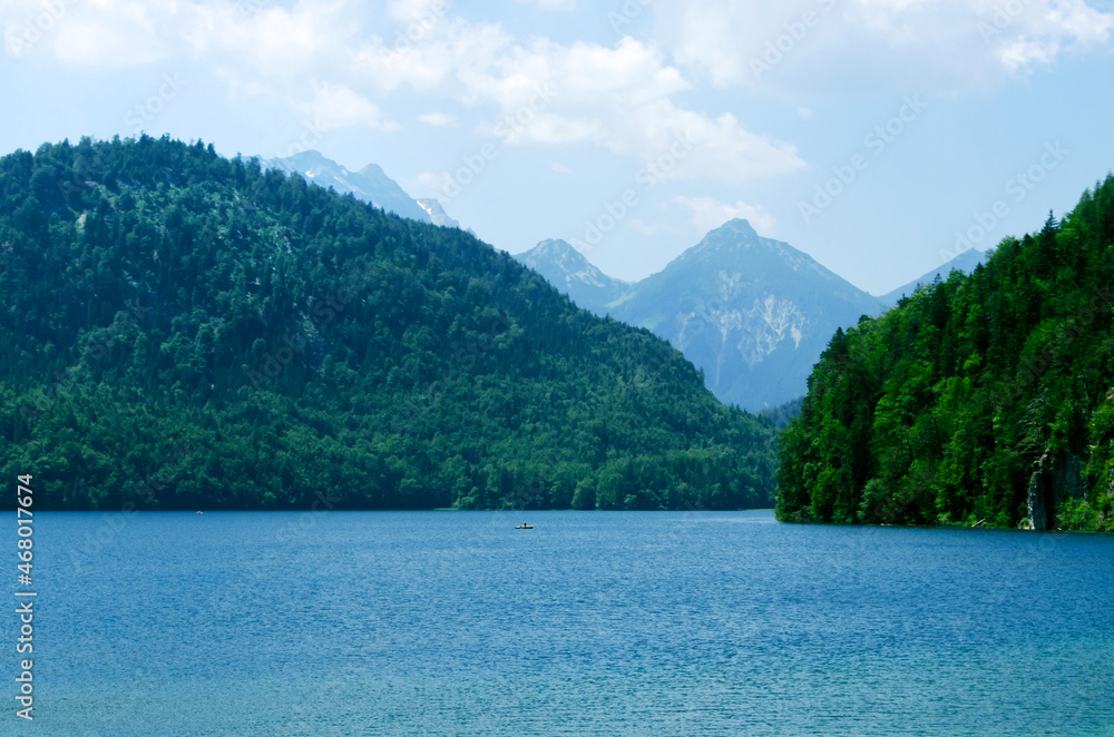 Alpsee lake landscape with Alps mountains near Munich in Bavaria, Germany. Crystal clear mountain lake and rocky mountains