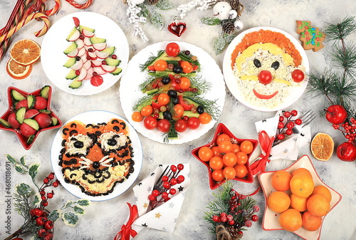 Christmas new year dishes, traditional festive salad with tiger and santa claus, symbol of the year, edible veggie trees made of vegetables and fruits, food design idea, fir branches and decorations 