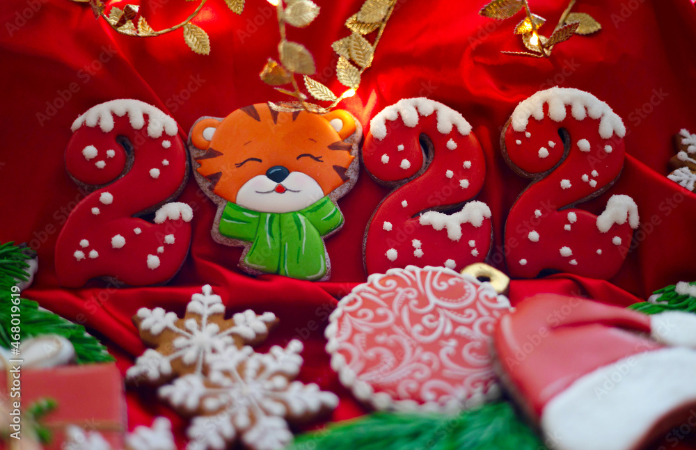 Banner for Christmas and New Year gingerbread cookies numbers 2022, snowflakes, Santa hat, Christmas trees, garlands on red silk fabric background, gingerbread tiger symbol Chinese zodiac calendar