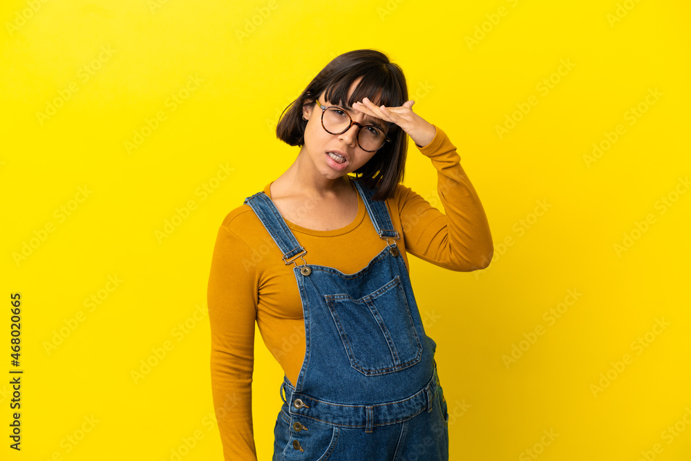 Young pregnant woman over isolated yellow background looking far away with hand to look something Young pregnant woman over isolated yellow background looking far away with hand to look something