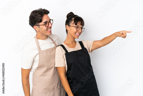Restaurant mixed race waiters isolated on white background presenting an idea while looking smiling towards