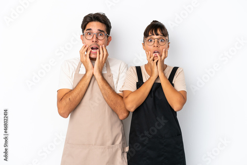 Restaurant mixed race waiters isolated on white background surprised and shocked while looking right