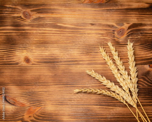 Natural wheat on wooden desk background with copyspace