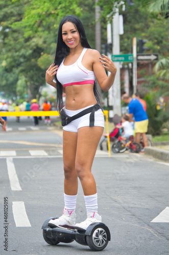 Latina woman smiling while skating in the street