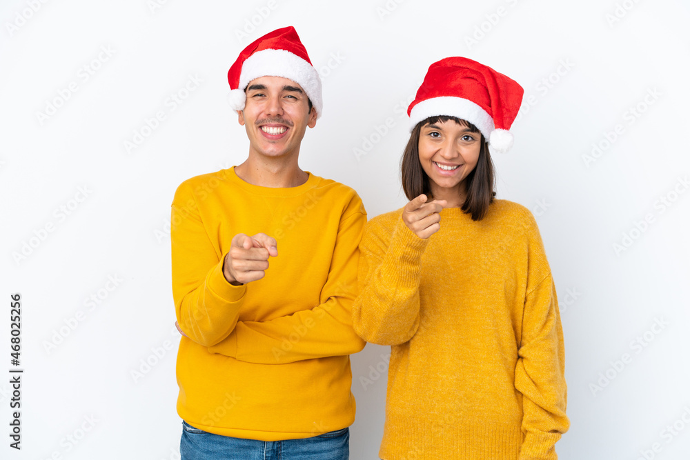 Young mixed race couple celebrating Christmas isolated on white background points finger at you with a confident expression Young mixed race couple celebrating Christmas isolated on white background points finger at you with a confident expression