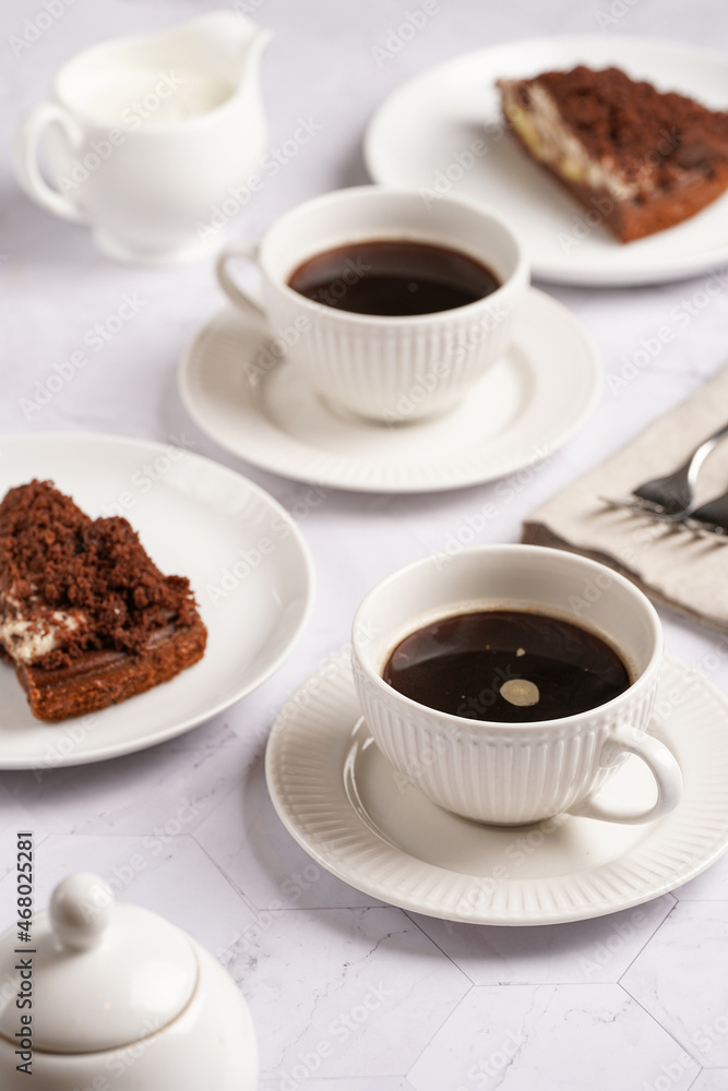 sweet breakfast - two white porcelain cups with coffee drink on a white saucer, piece of brown cake sweet breakfast - two white porcelain cups with coffee drink on a white saucer, piece of brown cake