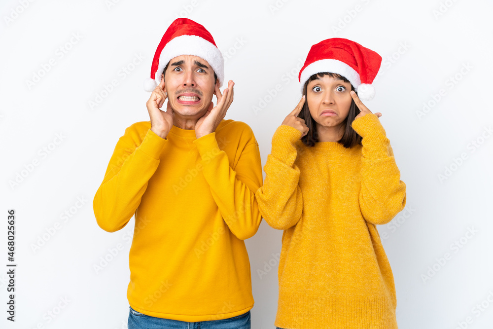 Young mixed race couple celebrating Christmas isolated on white background covering both ears with hands Young mixed race couple celebrating Christmas isolated on white background covering both ears with hands