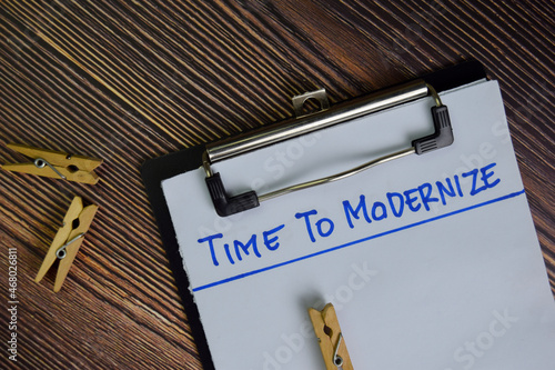 Fotografija Time To Modernize write on a paperwork isolated on Wooden Table.
