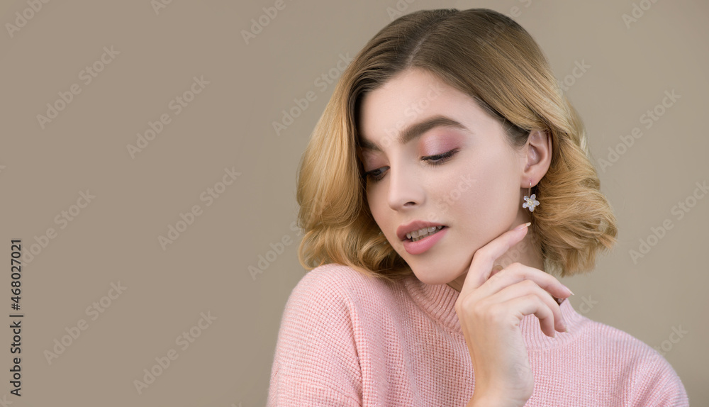 Portrait of beautiful young woman in pink sweater with perfect young skin and professional makeup. Winter seasonal beauty concept. Portrait of beautiful young woman in pink sweater with perfect young skin and professional makeup. Winter seasonal beauty concept.