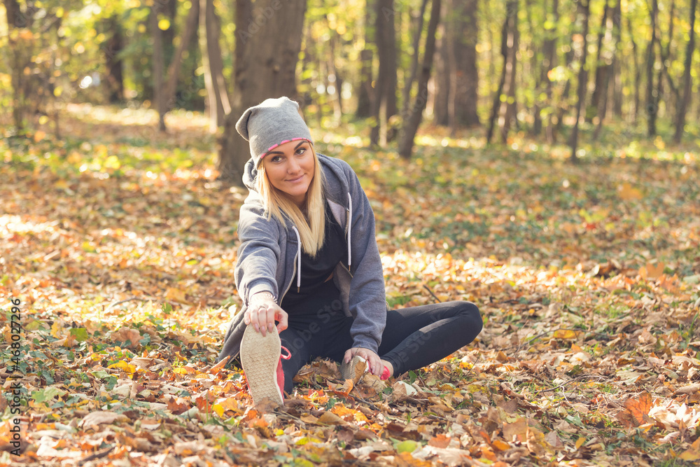 young woman stretching before running in the forest young woman stretching before running in the forest