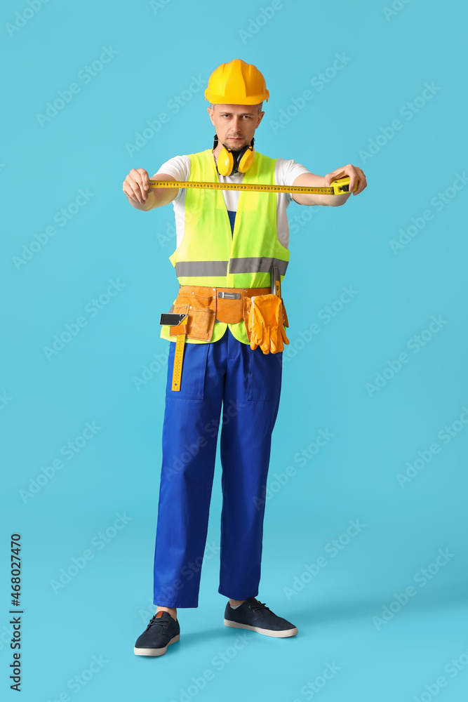 Male builder with tape measure on color background Male builder with tape measure on color background