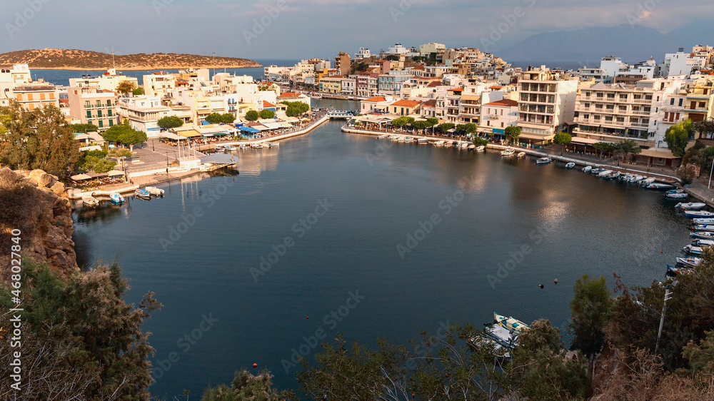 view from the mountains to the quiet harbor with boats in the Greek resort town of Agios Nikolaos