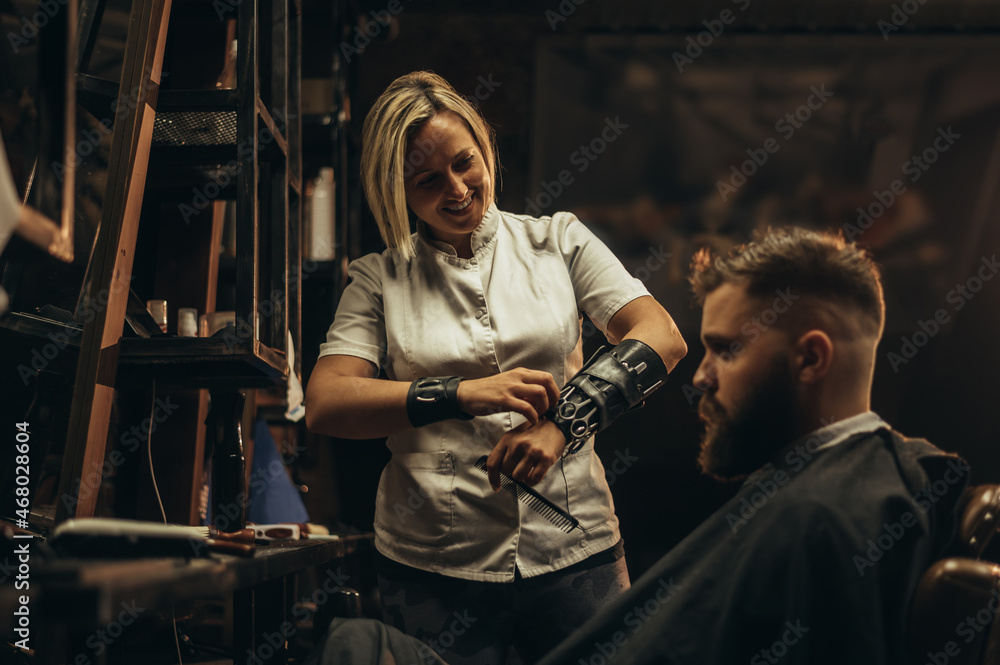 Professional barber wearing her tools on the forearm and working in her barbershop