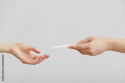 Female hands with menstrual pad on white background