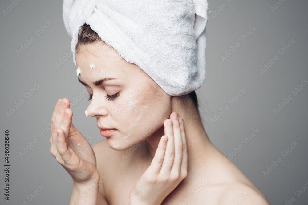 woman with bare shoulders towel on head face cream skin care woman with bare shoulders towel on head face cream skin care