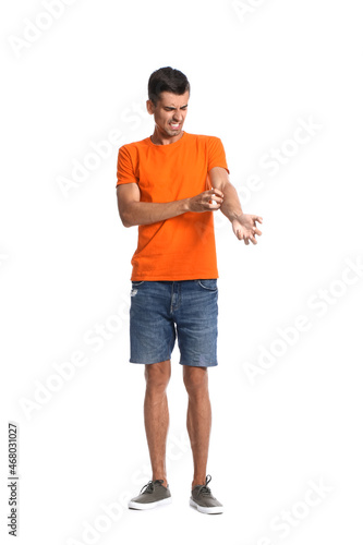 Young man scratching himsel...