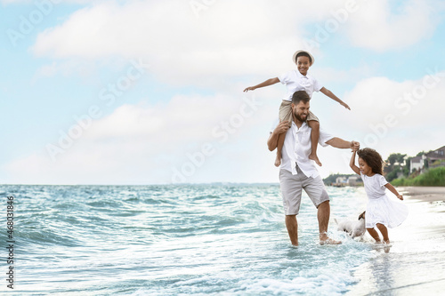 Happy family with cute dog on sea beach © Pixel-Shot