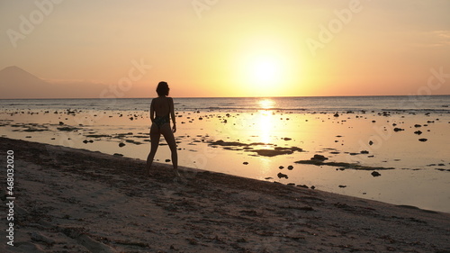 Girl walking on the beach at sunset island Indonesia travel Bali Gili T summer sun golden hour coast ocean relax nature adventure woman