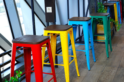 Red yellow green and blue chairs stand by the window  colorful vintage style furniture