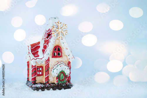 Gingerbread house christmas decoration on snow with bokeh background