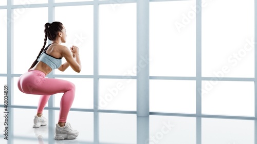 Attractive young woman in sportswear doing morning exercises, female physical activity