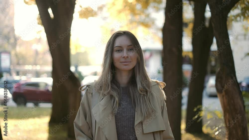 Blonde smiling woman outdoors in lens flares in autumn Blonde smiling woman outdoors in lens flares in autumn