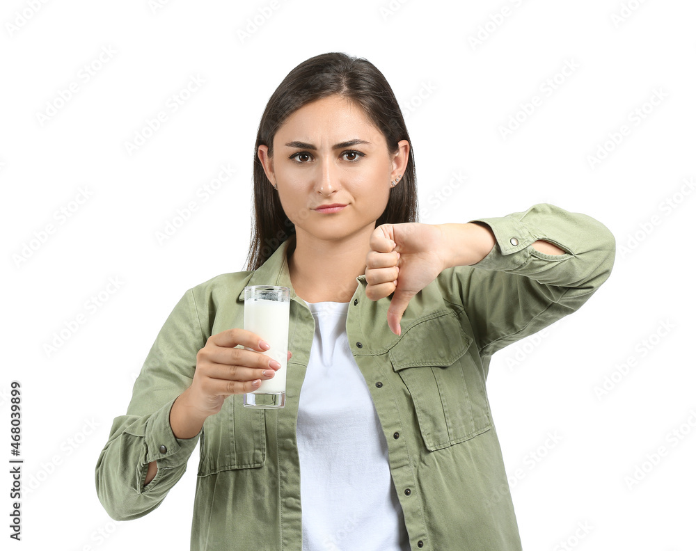 Young woman refusing to drink milk on white background Young woman refusing to drink milk on white background