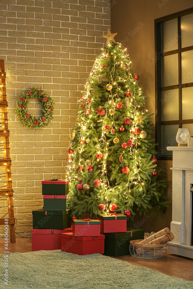 Beautiful mistletoe wreath with Christmas tree and gifts in interior of room Beautiful mistletoe wreath with Christmas tree and gifts in interior of room