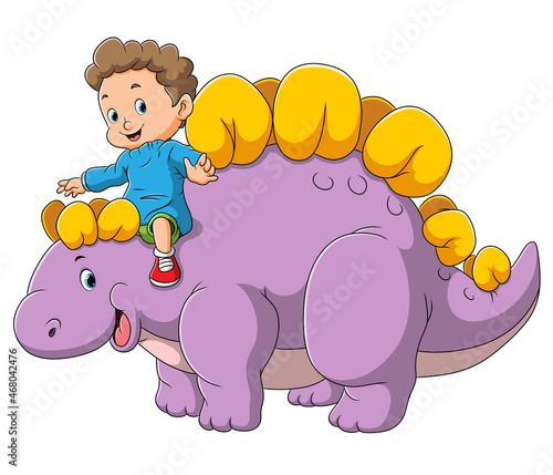 The cute boy is playing with the dinosaur stegosaurus
