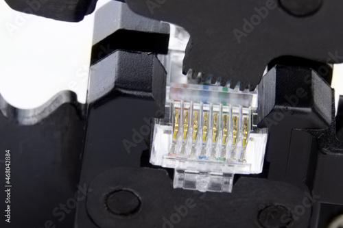 Compression of the Internet connector using a crimper for crimping RJ 45. Internet Network Connector, rj45.Crimping of a unified connector used in telecommunications. Unified connector 8P8C photo