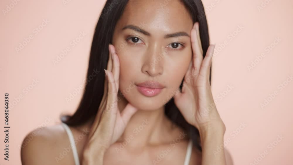 Female Beauty Portrait. Beautiful Diverse Asian Brunette Woman Posing, Smiling, Touching Her Face with Natural, Healthy Skin. Wellness and Skincare Concept on Soft Isolated Background. Close Up. Female Beauty Portrait. Beautiful Diverse Asian Brunette Woman Posing, Smiling, Touching Her Face with Natural, Healthy Skin. Wellness and Skincare Concept on Soft Isolated Background. Close Up.