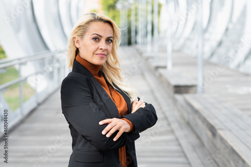 Business woman standing with her arms crossed looking at camera outdoors
