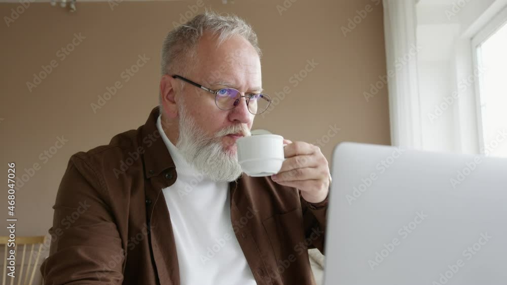 man with glasses works on a laptop at home man with glasses works on a laptop at home