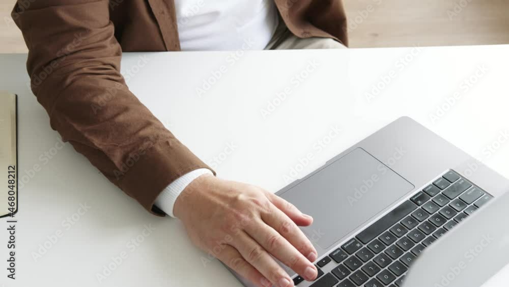 man typing on a laptop on a white table man typing on a laptop on a white table