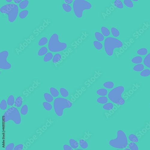 blue footprints of a cat on a green background. seamless abstraction of animal footprints for clothing or print