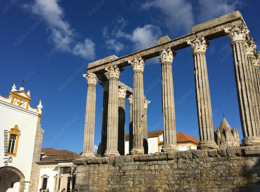 Ruins columns in Évora, Portugal. Ancient temple and church with deep blue sky with a few clouds in sunny day