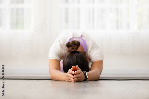 Cloese up hand.Asian woman working out in sportswear while doing yoga, seated in Child exercise, Balasana stance.