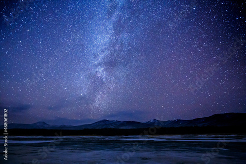 Starry sky over a frozen winter lake. Milky Way. Sikhote-Alin Biosphere Reserve in the Primorsky Territory.