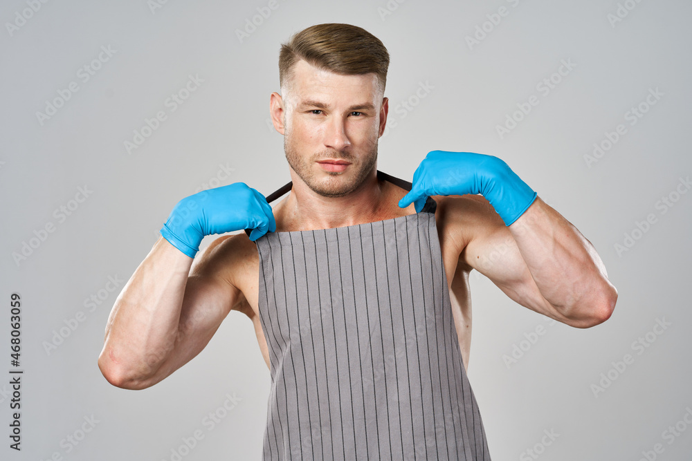 pumped up man in apron wearing rubber gloves posing cleaner