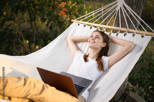 woman lies in the corner with laptop vacation nature technology