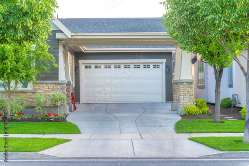 Garage of a house with concrete driveway intersecting with the sidewalk at Daybreak, Utah photo
