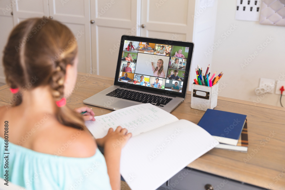 Caucasian girl using laptop for video call, with smiling diverse elementary school pupils on screen Caucasian girl using laptop for video call, with smiling diverse elementary school pupils on screen