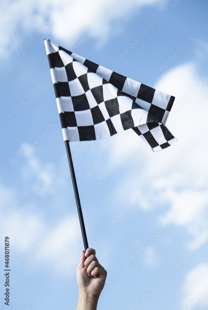 Hand Holding Racing Flag On Sky Background