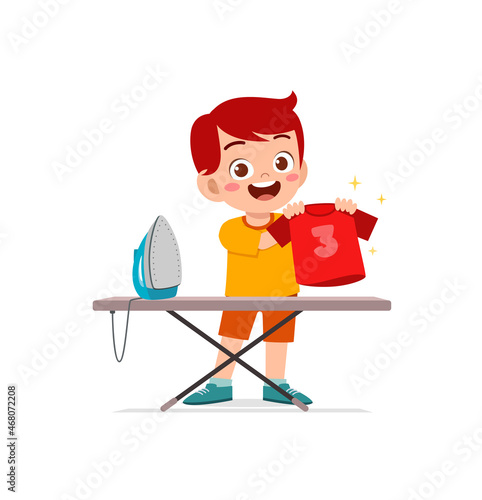 little boy use electric iron to smooth clothes